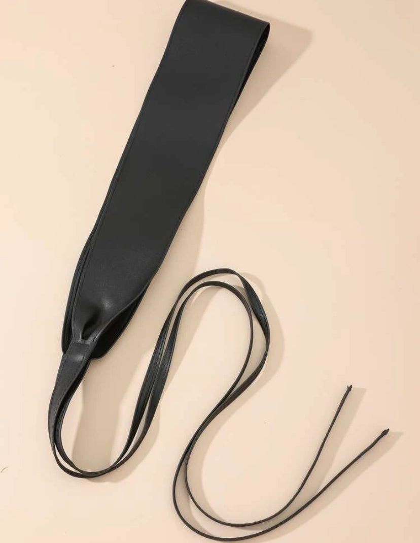 Black Obi Wrap Belt with a wide, smooth band and long adjustable ties displayed flat on a beige surface.