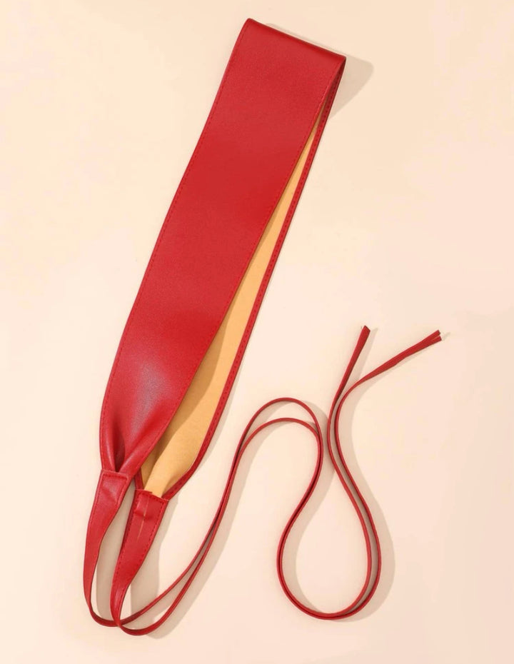 Red Obi Wrap Belt made of smooth material, featuring a wide design with long adjustable ties, displayed on a beige background.