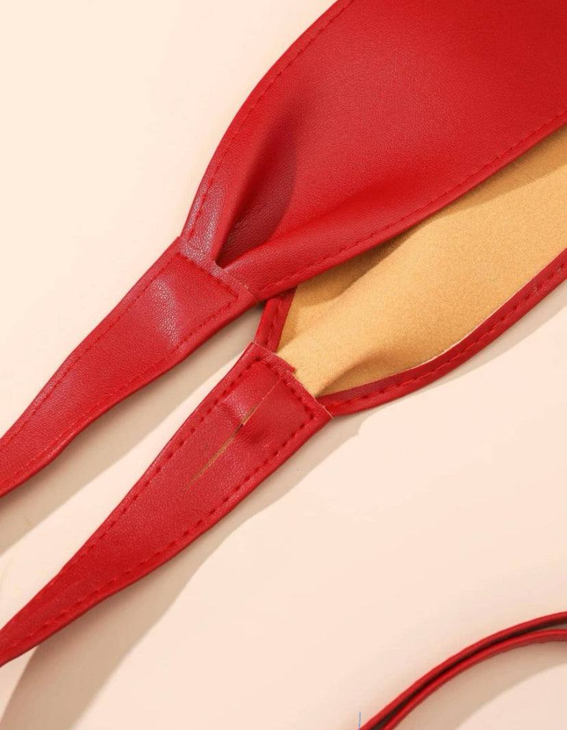 Close-up of a red obi wrap belt showcasing its smooth texture, stitching details, and contrasting beige inner lining.